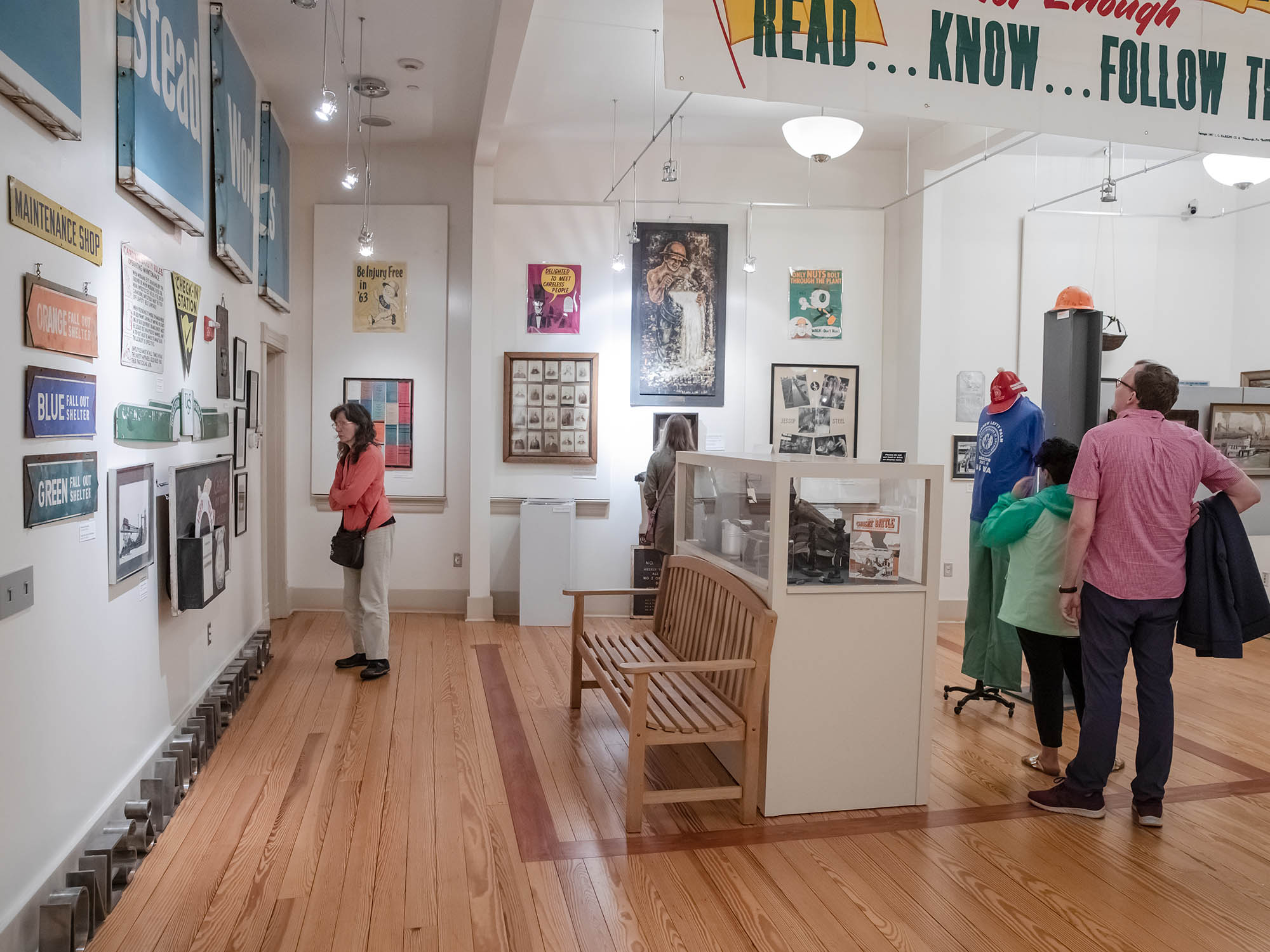 Museum patrons walk through a gallery and look at artifacts