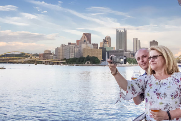 Selfie with Skyline 1600 x 1000 Couple takes a selfie from the riverboat with the skyline of Pittsburgh in the background.