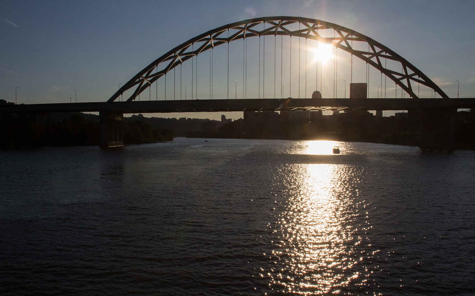 Low sun reflects off the Mon River with silhouette of the Birmingham Bridge