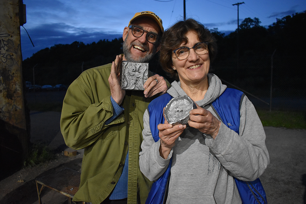 two participants hold up their completed castings