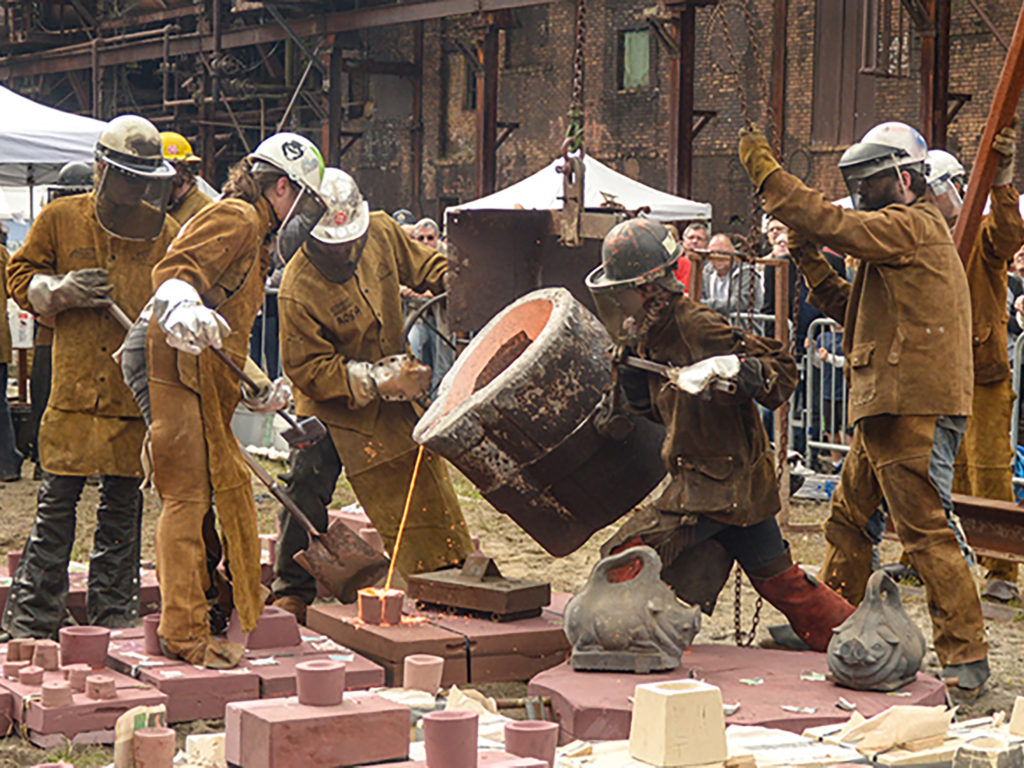 metal arts participants handling a large bull ladle