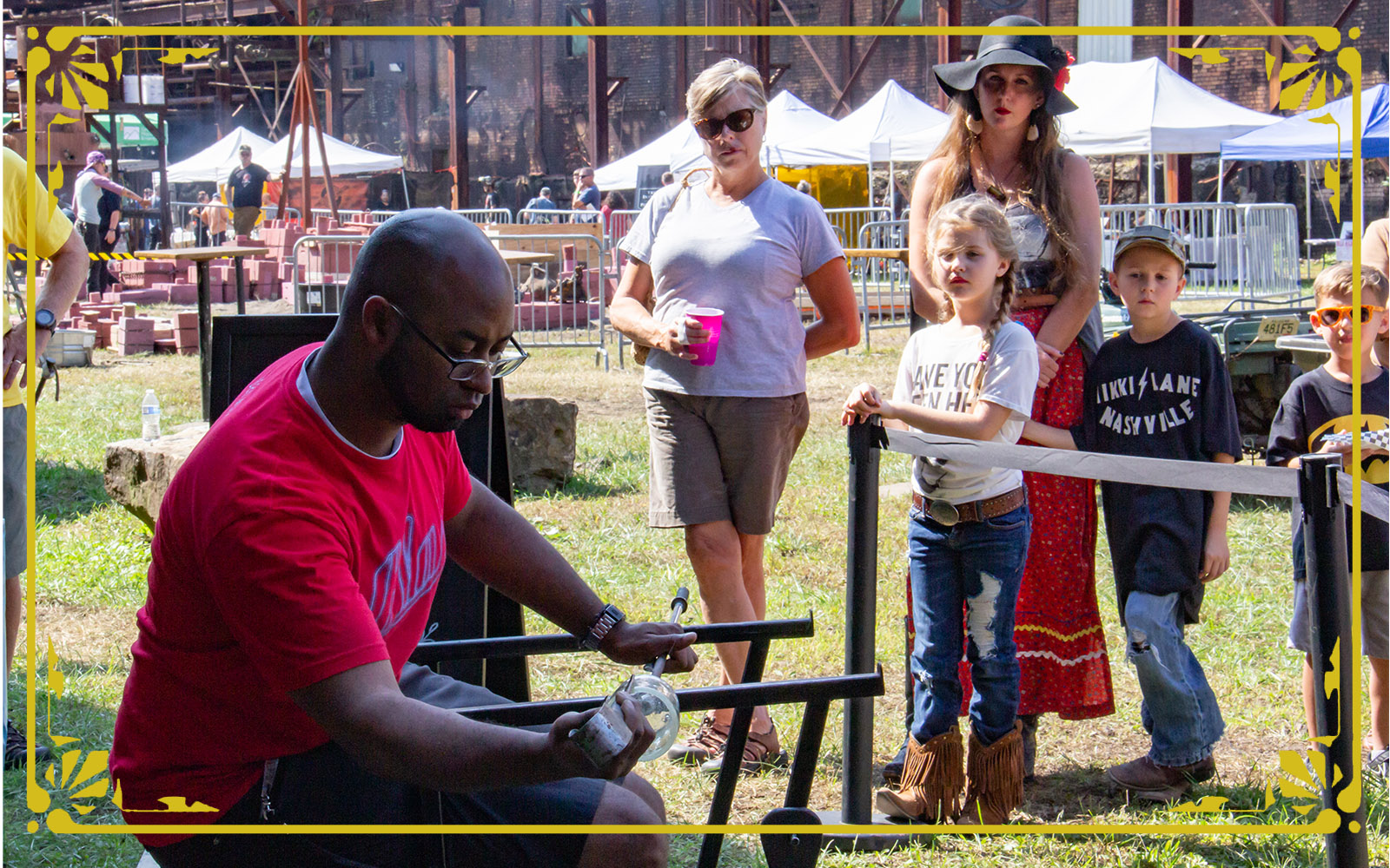 artists from the pittsbrugh glass center demonstrate glass blowing techniques for interested onlookers