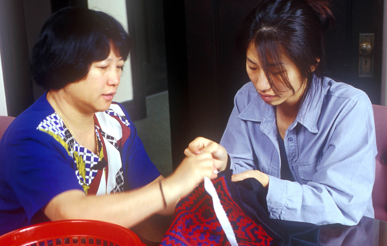 master artists teaches traditional needlework to apprentice