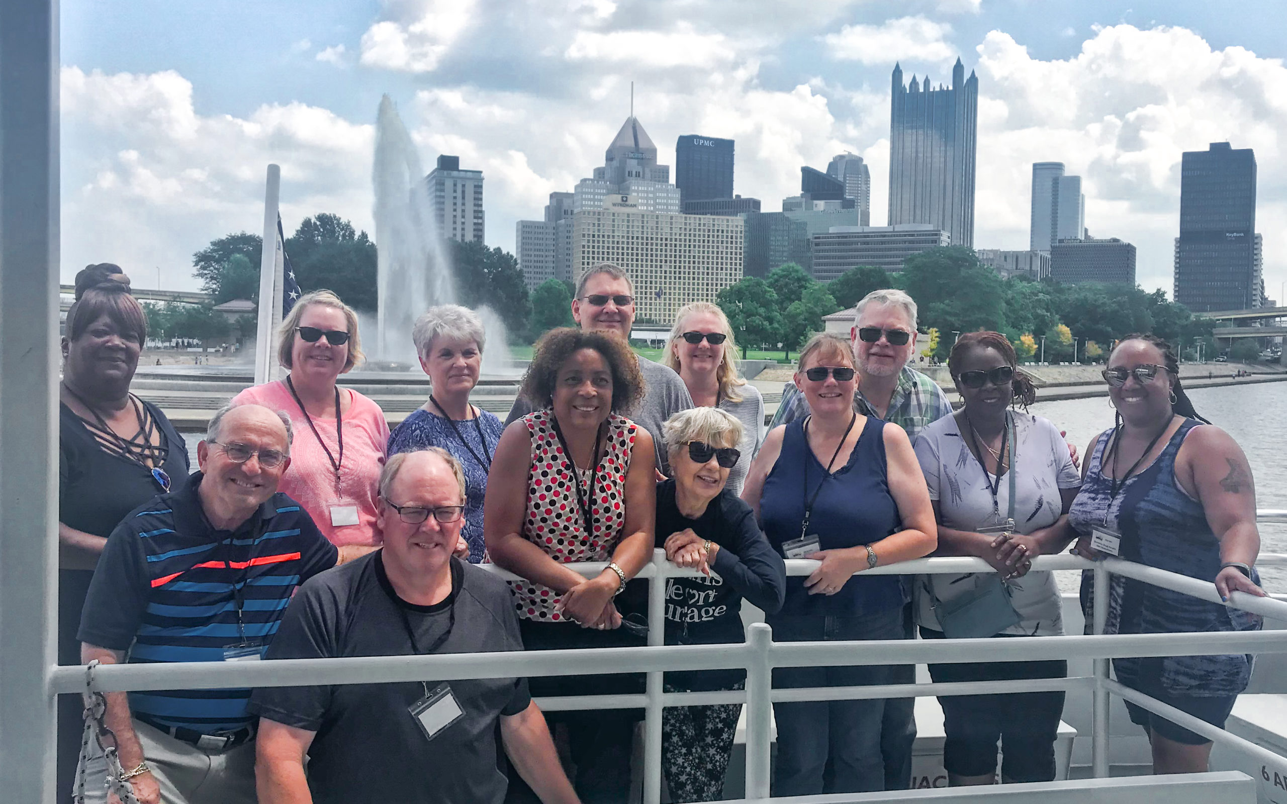 tour group poses for photo with point state park in the backgroun