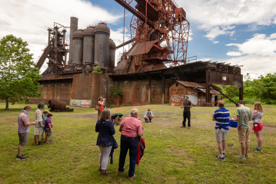 Clusters of Families stand six feet or more apart in the ore yard.