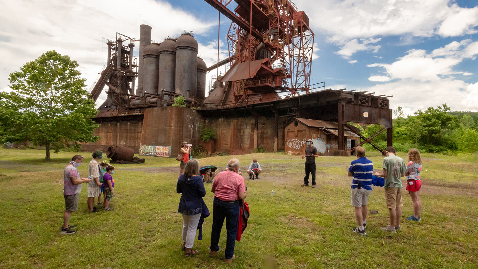 Clusters of Families stand six feet or more apart in the ore yard.