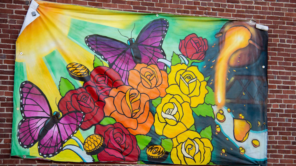 Mural of flowers, butterflies, sun, and molten iron