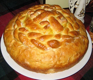 A round loaf of bread with a braided top.