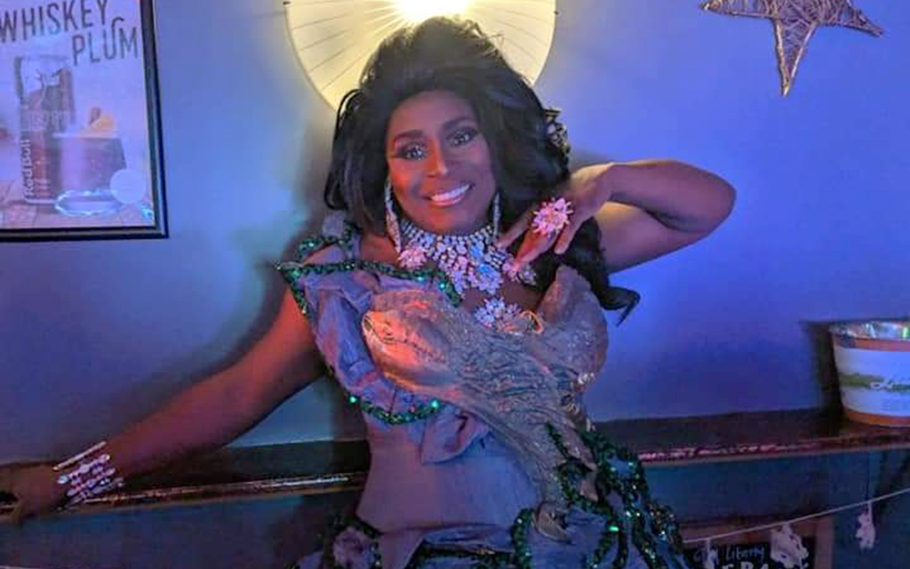 A black drag queen in purple light.