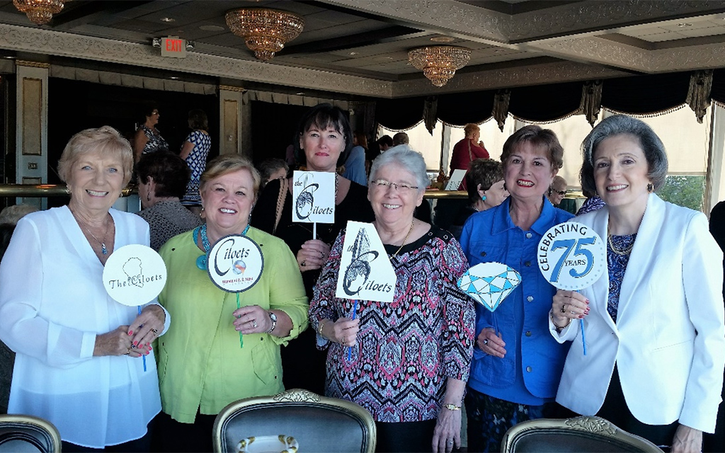 Six women gather holding signs showing various Ciloet logos