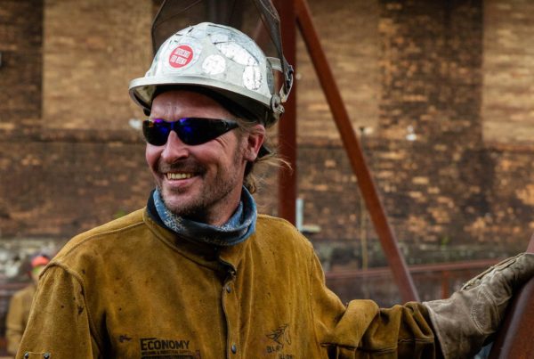 Ed Parrish shown smiling in his hard hat, sunglasses, and leathers.
