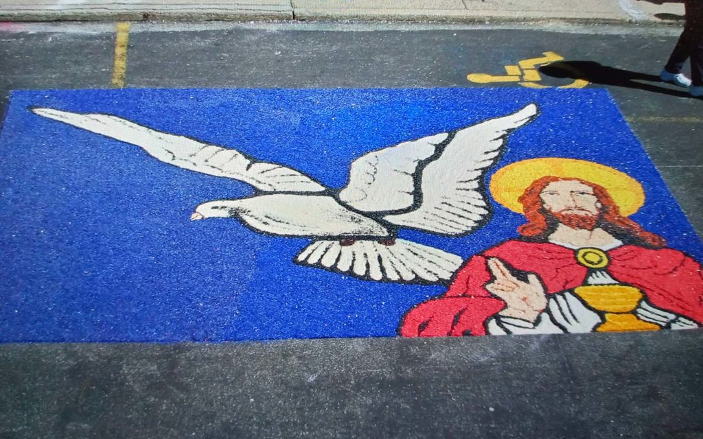 a sawdust carpet featuring Jesus and a dove