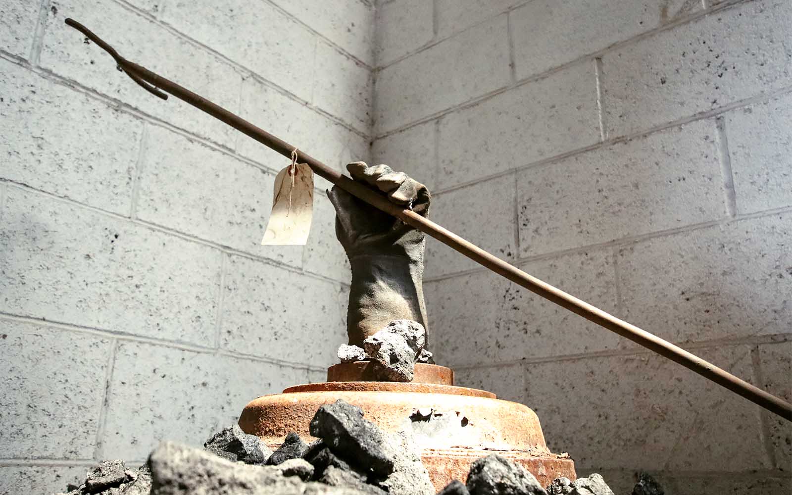 A cast iron glove holding a tool