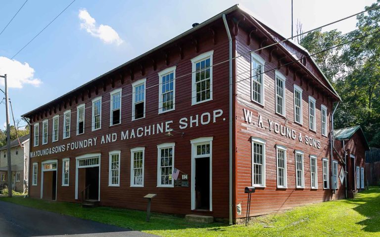 A red clapboard building with dozes of six-over-six windows.
