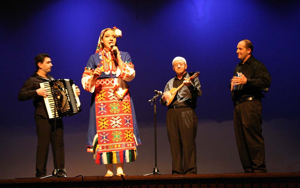 A woman sings with three musicians behind here