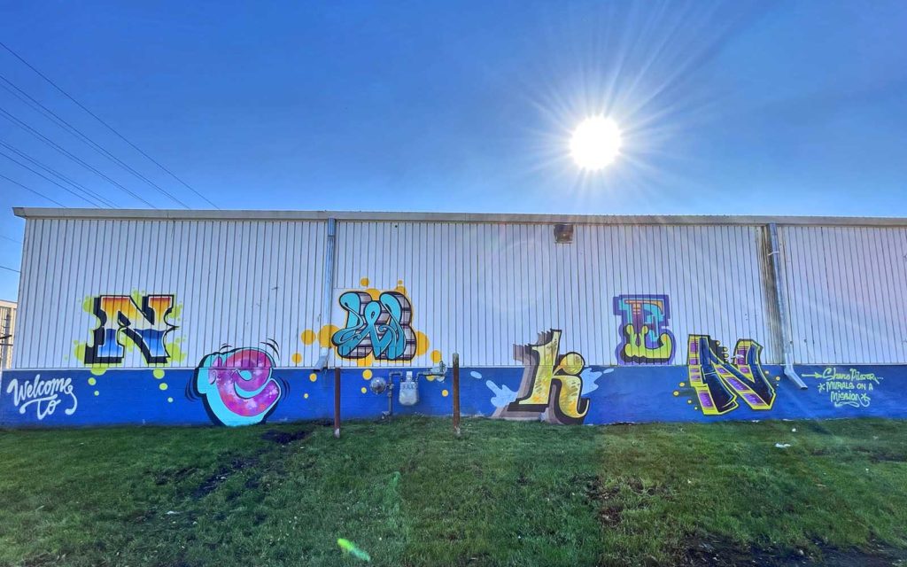 A mural reads "Welcome to New Ken'