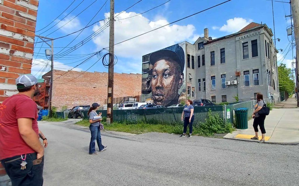 Four people look up at a mural.
