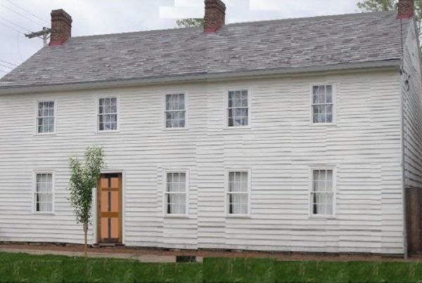 A two story clapboard house with five windows on the upper level, and four on the bottom with an offset door to the left.