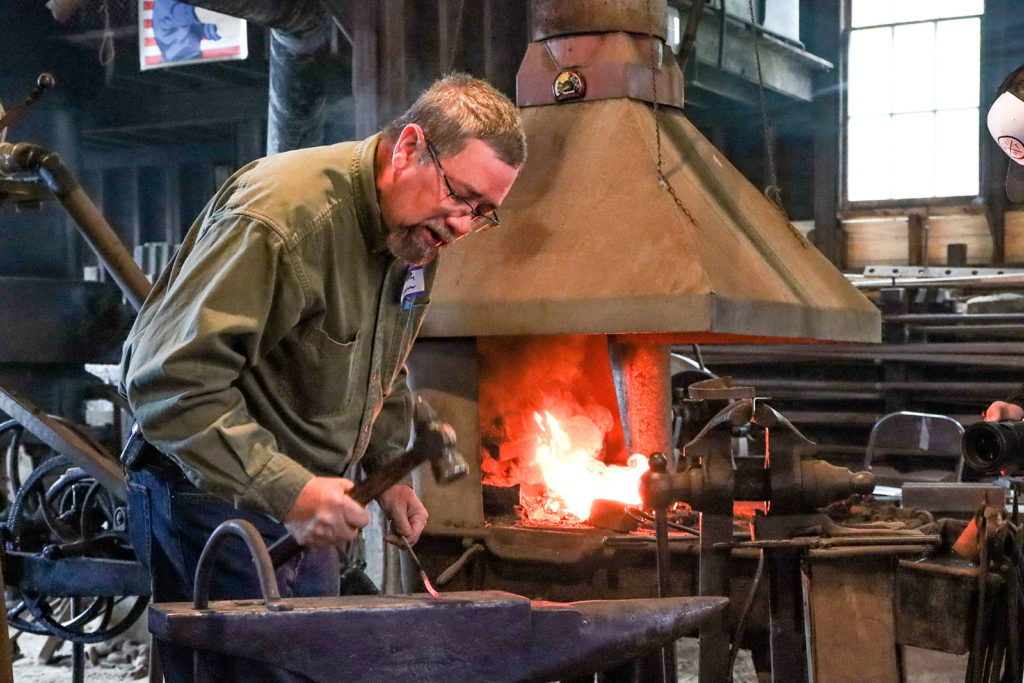 A blacksmith hammers on an anvil.