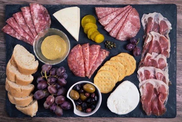 A Charcuterie board with meats, bread, crackers, cheese, olives, etc.