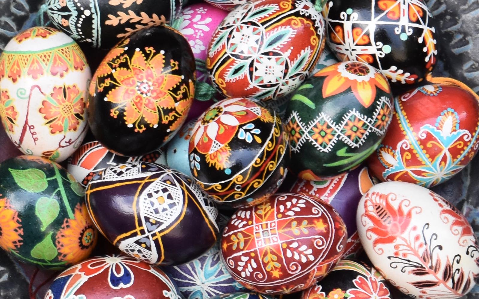 A bowl full of decorated pysanky eggs.