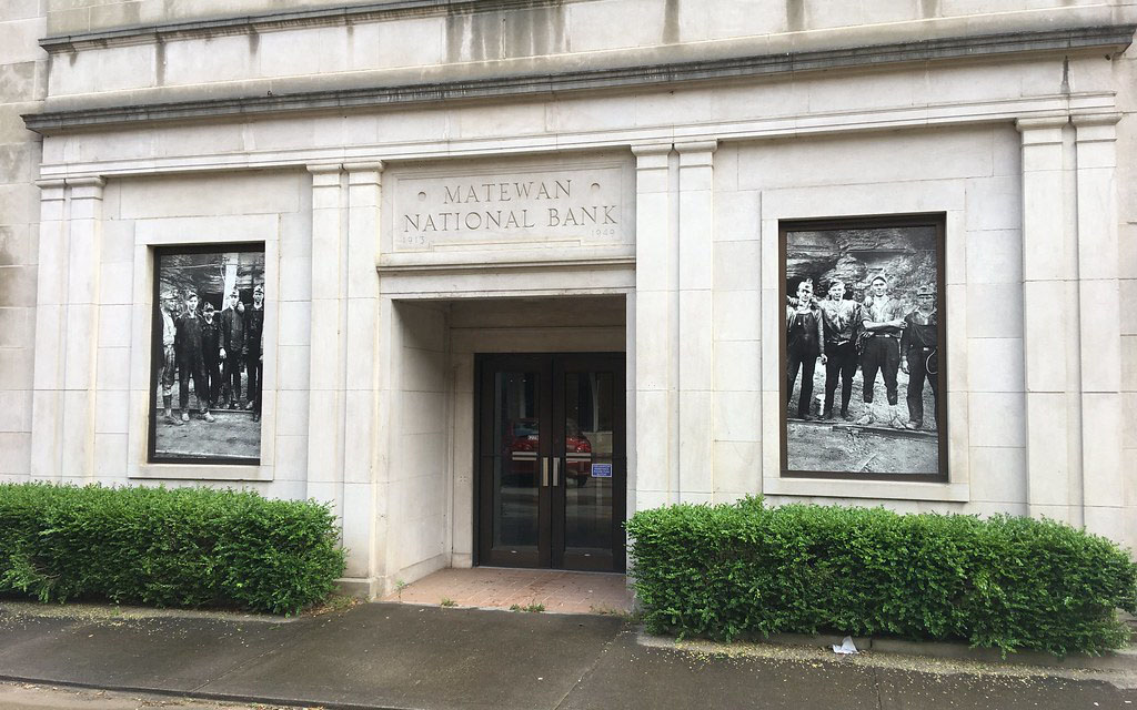 An old bank building with photos of workers in the windows.