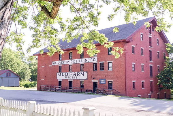 A four-story red brick barrel house which has "West Overton Distilling Co." and "Old Farm Rye" painted on it.