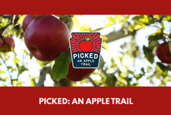 Red apples on a tree with text reading Picked An Apple Trail