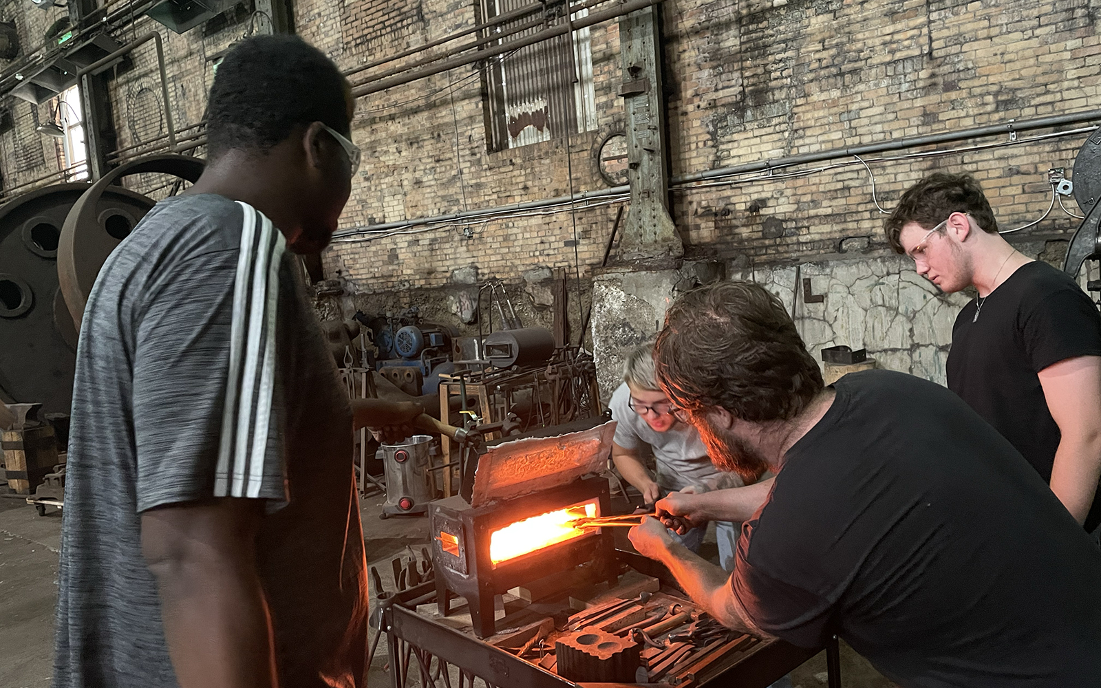 blacksmith jared Ondovchik works with students on blacksmithing basics
