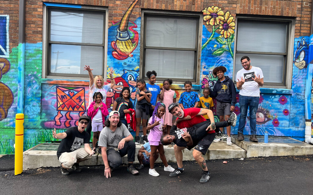 Students pose with rivers of Steel artists in front of a new mural created with the Rankin Christian Center in Raknin, Pennsylvania