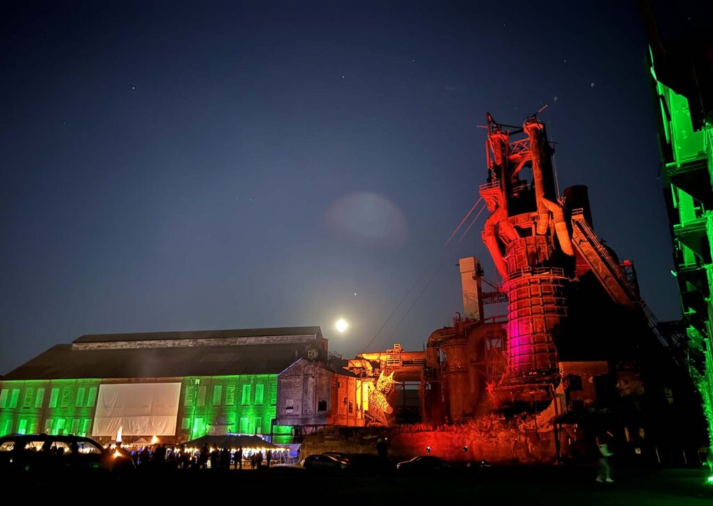 The Furnaces at night, awash in colored lights.