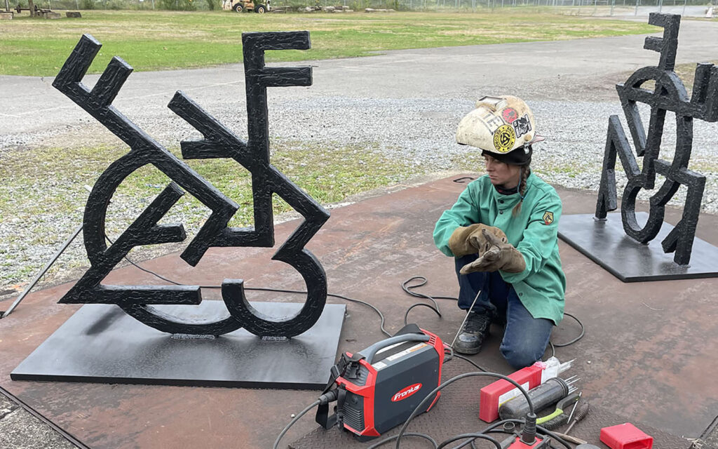 Paige Henry installs artworks at carrie furnaces