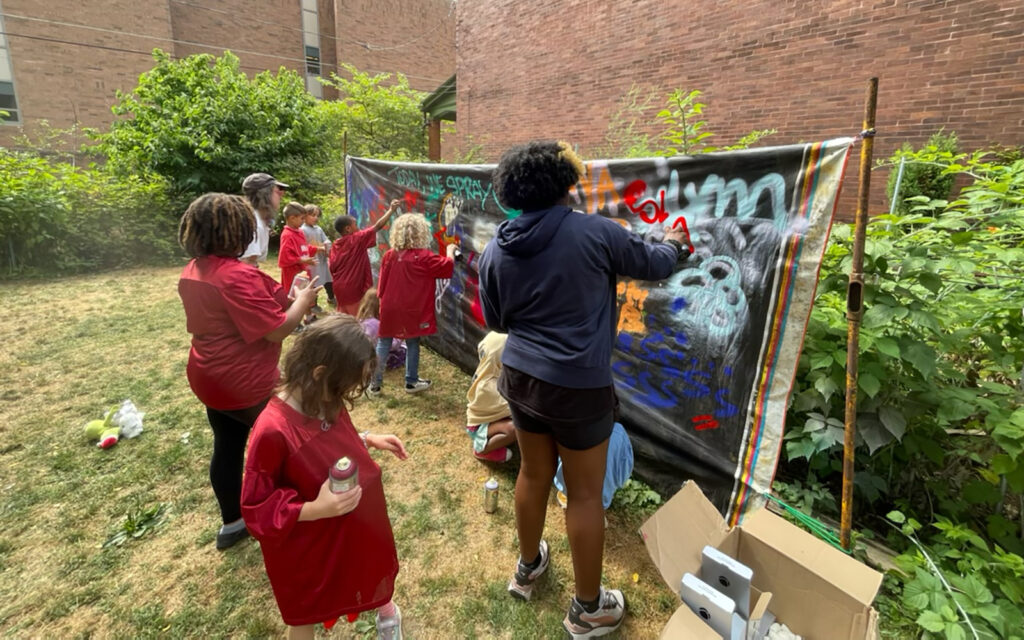 kids work on graffiti murals during Art in the Garden summer camp