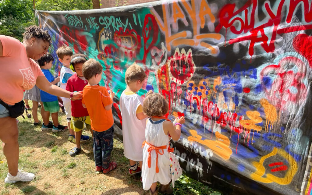 kids work on graffiti murals during Art in the Garden summer camp