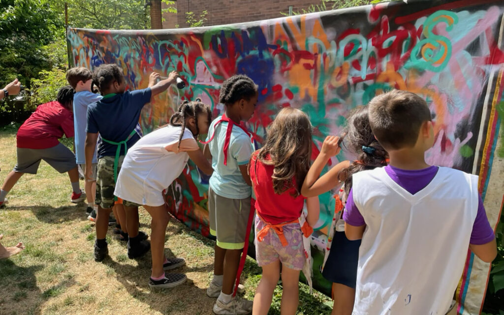 kids work on graffiti murals during Art in the Garden summer camp