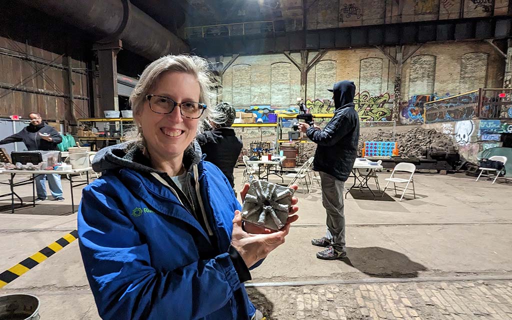 a woman show off her finished aluminum cast project