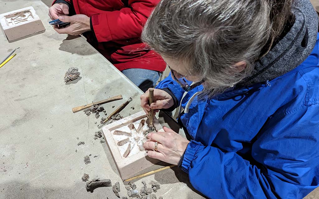 a women cleans out her mold that will be cast with aluminum