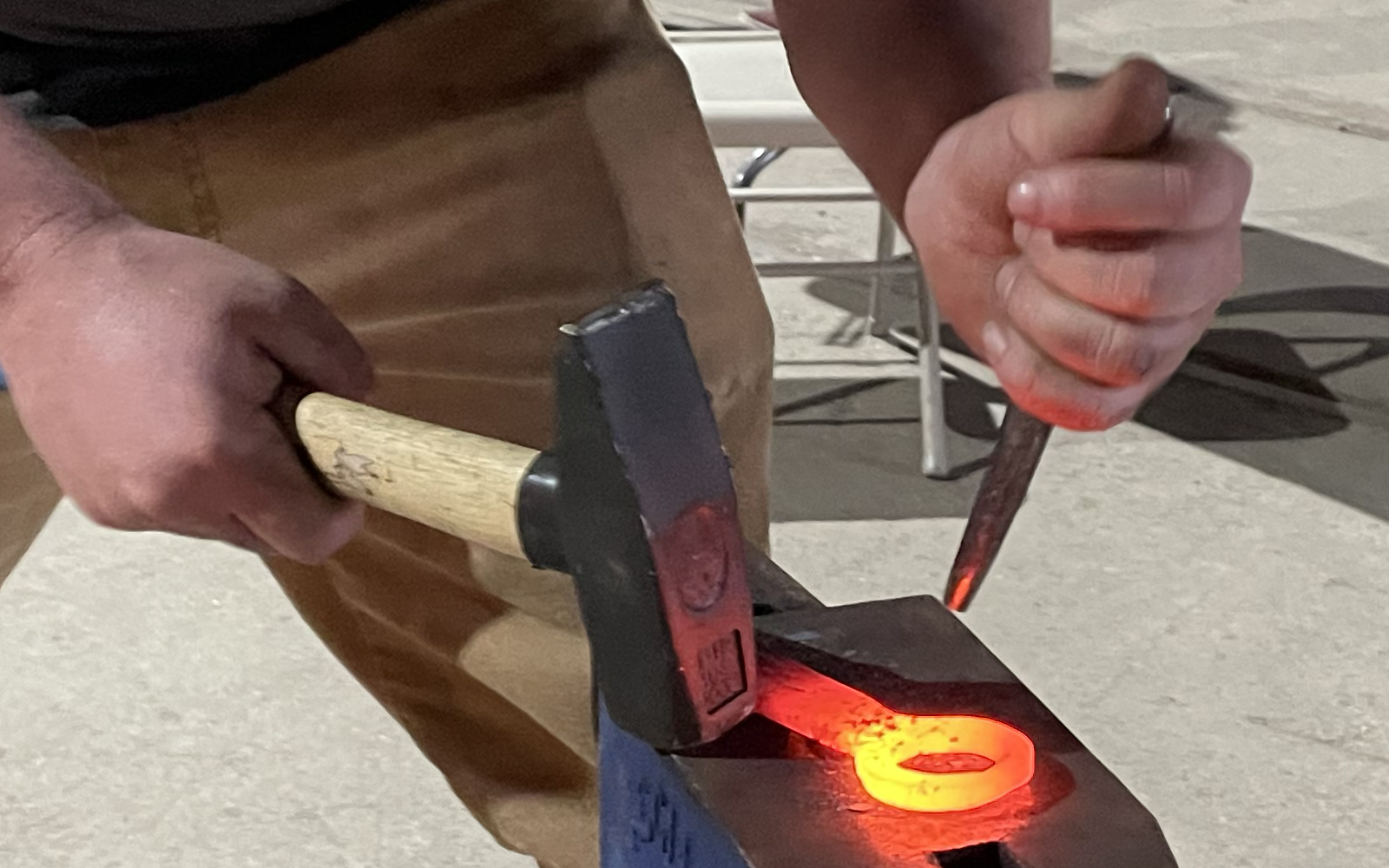 close up image showing the glowing hot bottle opener being worked by the teaching technician
