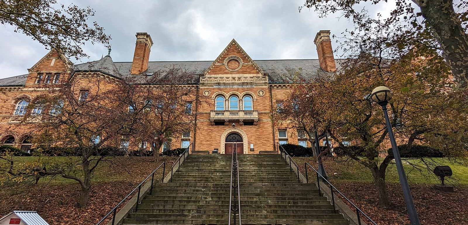 An expansive orange brick building with a long set of steps up to it.