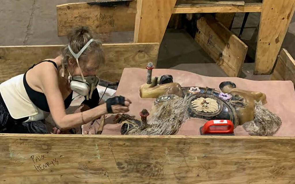 workshop participant Marsha tells works on the mold of her rocking horse cast during a weeklong iron intensive.