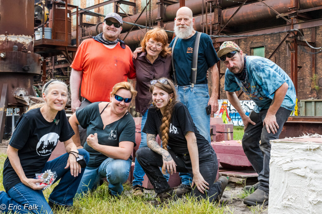 Rivers of Steel metal artists pose for a photo with visiting artists after an iron pour