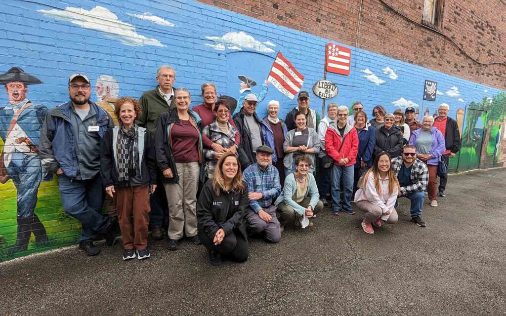a group shot of daytrippers posed in front of a mural