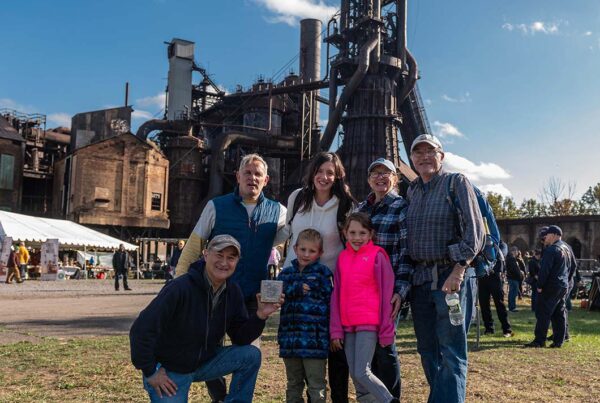 A multi-generational family poses in front of Furnace #7.