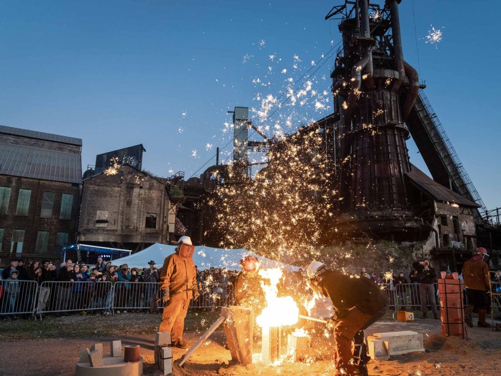 Sparks fly from a performance pour in front of the historic furnaces.