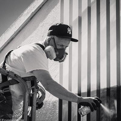 Artist Mr. June works on a mural