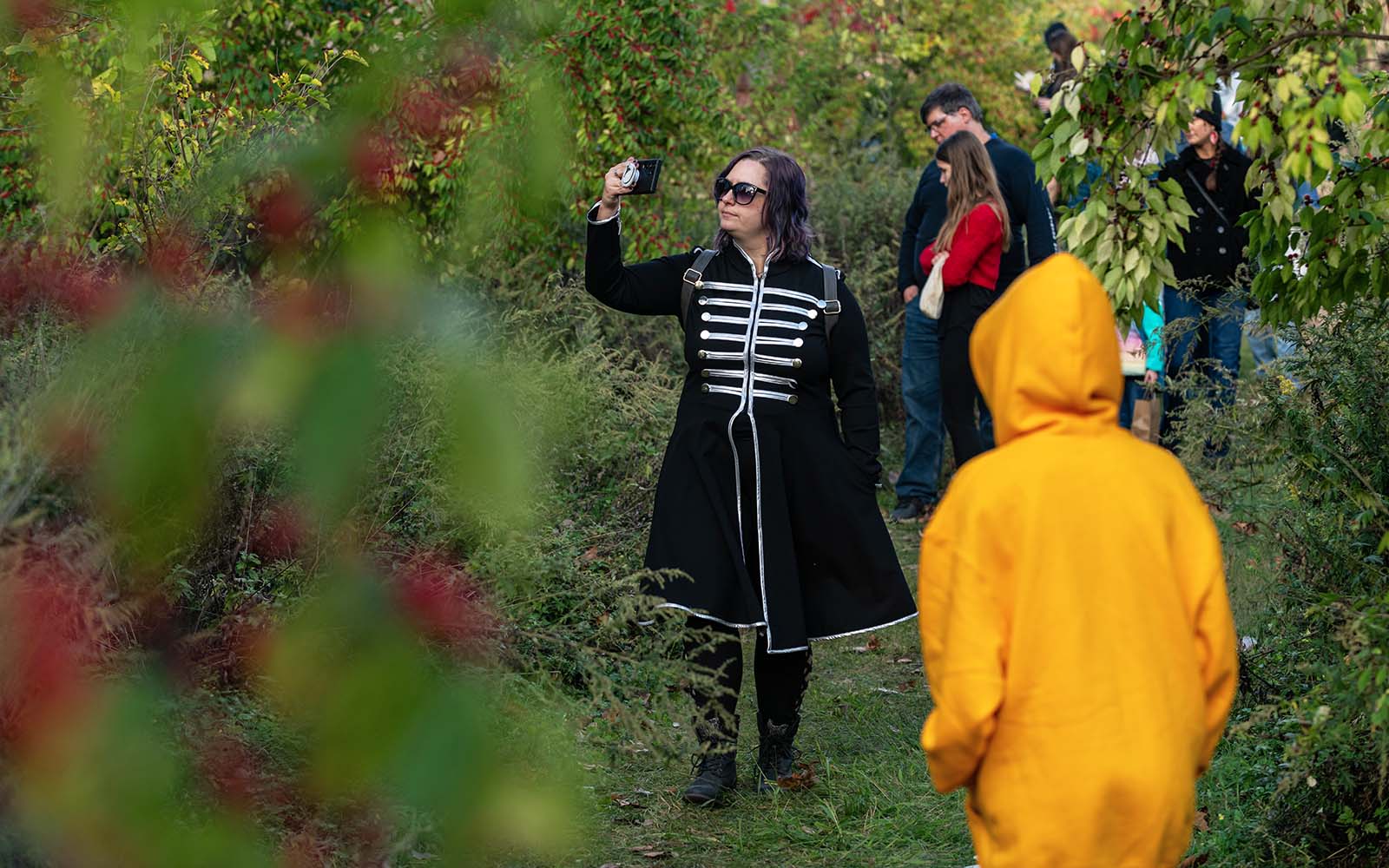 A woman lifts her phone to photograph the Iron Garden.