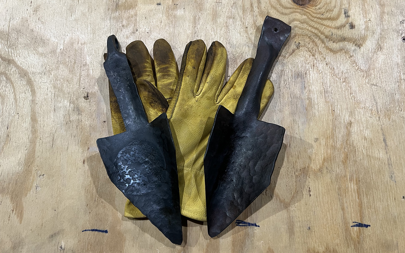 image shows two forged trowels and work gloves.