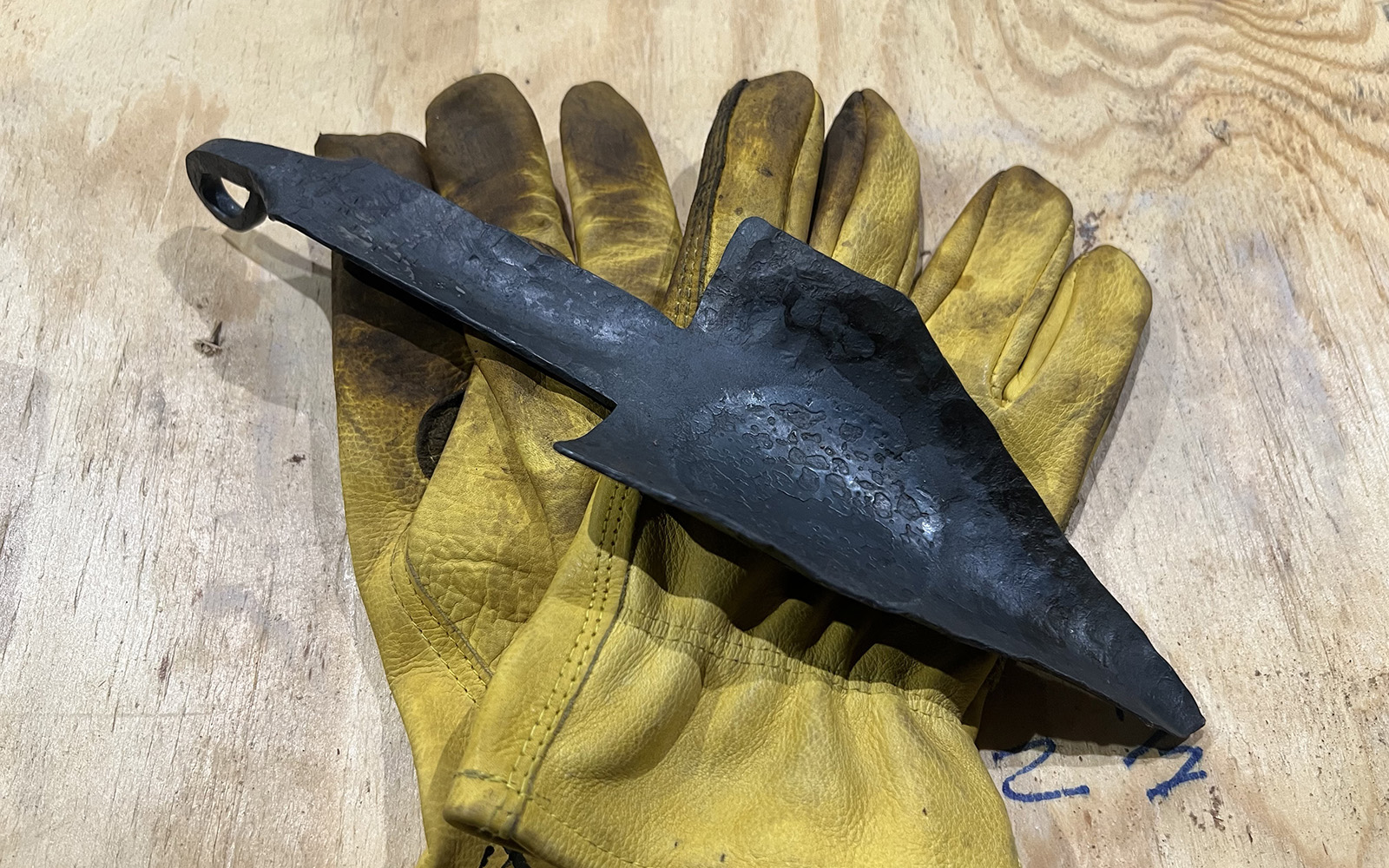 image shows a forged trowel and work gloves.